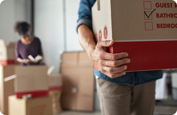 Couple préparant des cartons pour un déménagement international avec Grospiron