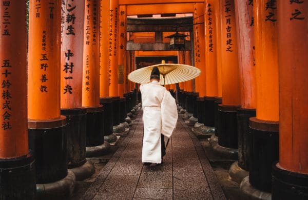 Personne en kimono avec un parapluie dans un sanctuaire japonais, symbole de l’expatriation au Japon