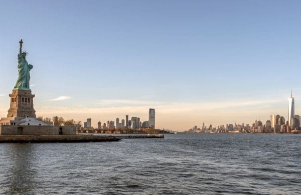 Statue de la Liberté et skyline de New York au coucher du soleil, expatriation avec Grospiron