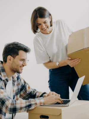 Couple organisant un déménagement avec ordinateur et cartons
