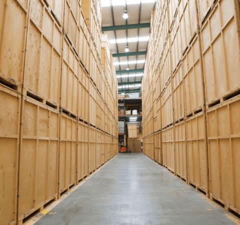 Allée entre conteneurs bois dans un entrepôt Grospiron, stockage professionnel