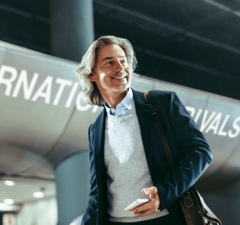 Homme souriant à l'aéroport après une relocalisation avec Grospiron