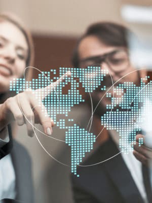 professionnels pointant une carte numérique illustrant le réseau mondial de Grospiron