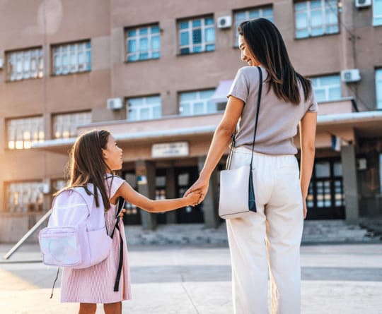 Mère et fille devant une école pendant l'installation scolaire avec Grospiron